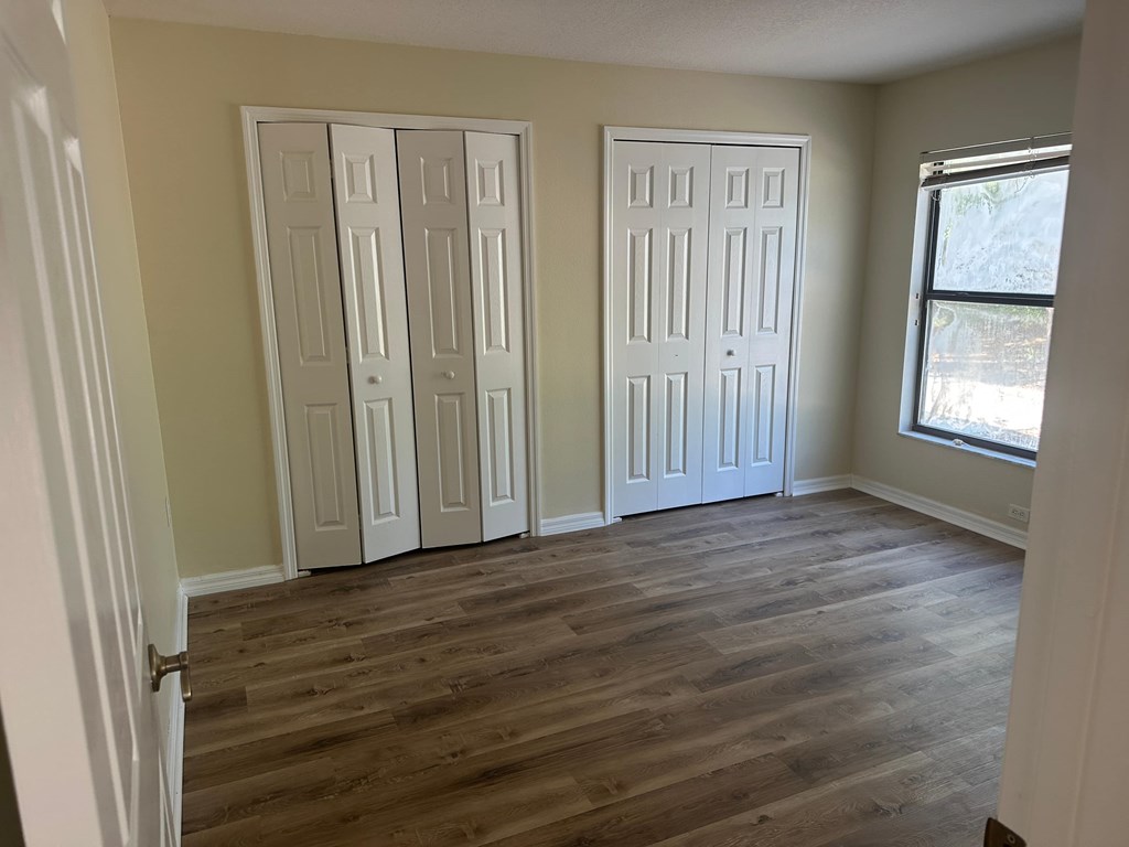 A room with two white doors and a window.