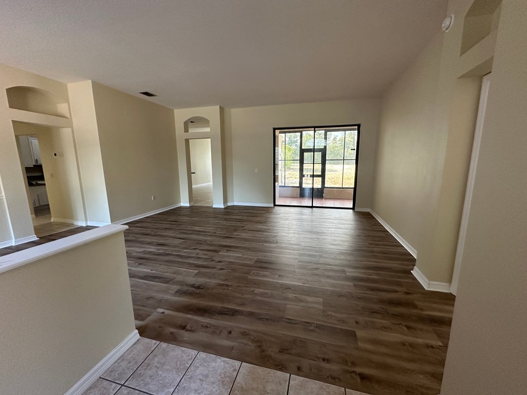 A room with wooden flooring and a sliding glass door.