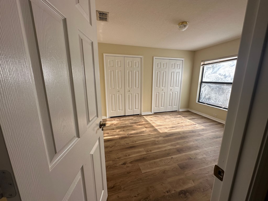 A room with white doors and wooden floors.