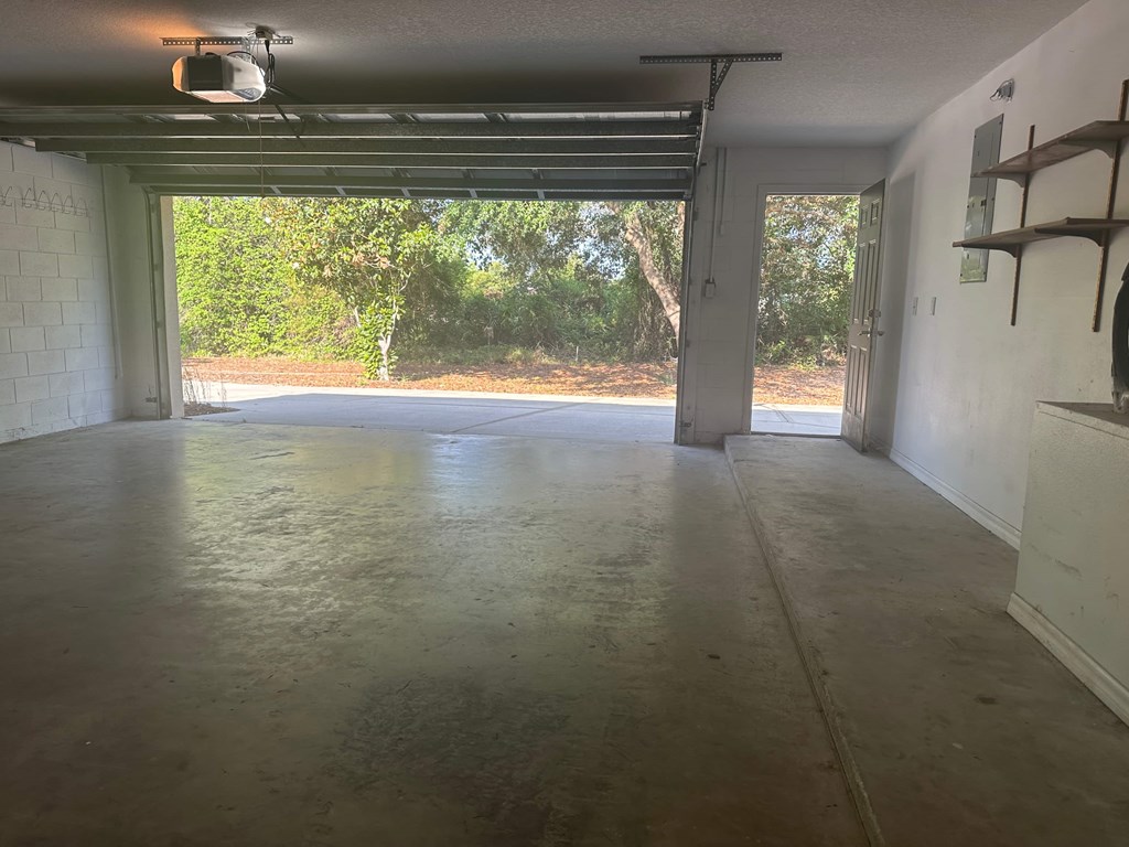A spacious garage with a concrete floor and white walls.