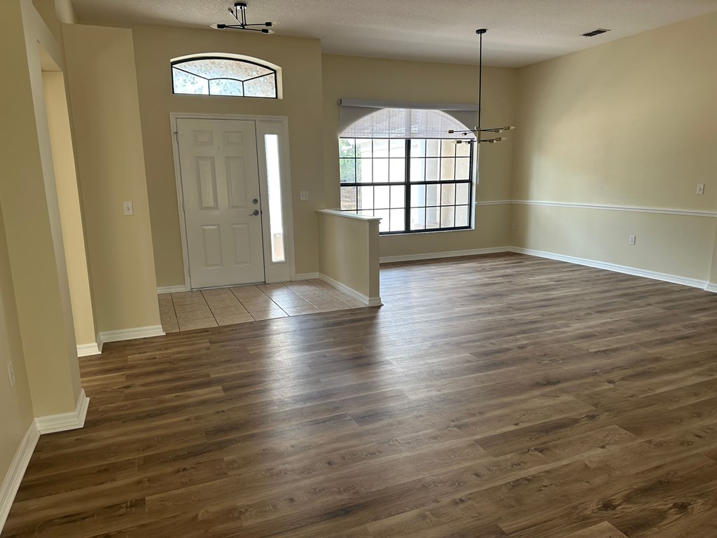 A room with wooden flooring and a white door.