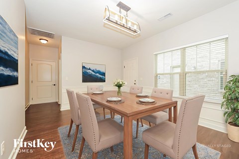 A dining room with a wooden table and chairs.
