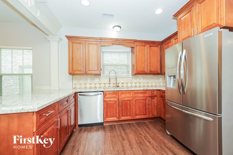 A kitchen with wooden cabinets and a stainless steel refrigerator.