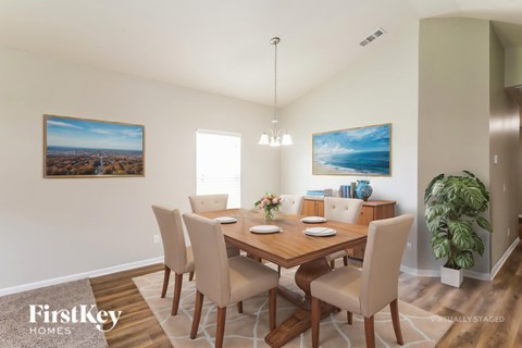 A dining room with a wooden table and chairs.