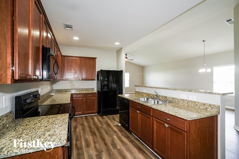 A kitchen with wooden cabinets and a granite countertop.