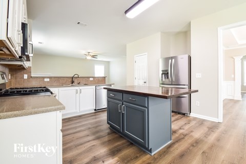 A kitchen with a stove top oven and a refrigerator.