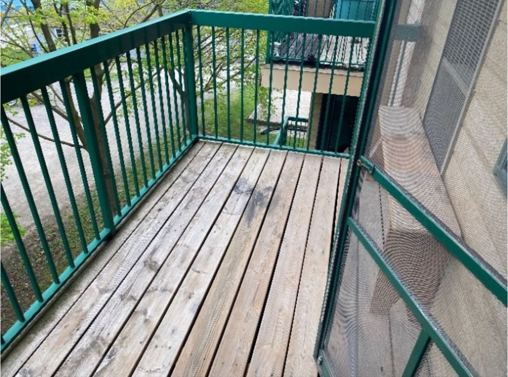A wooden deck with a green railing.