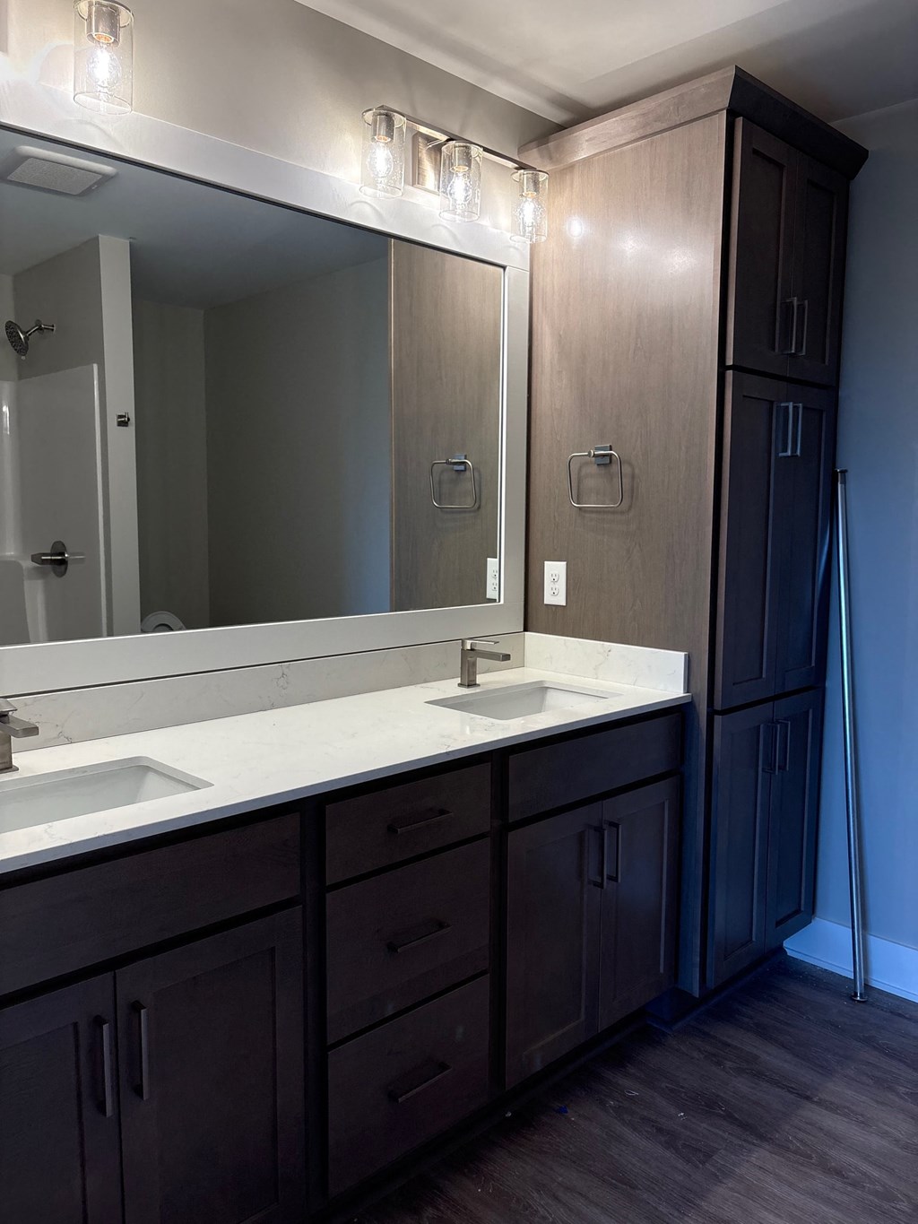 A bathroom with a sink, mirror, and wooden cabinets.