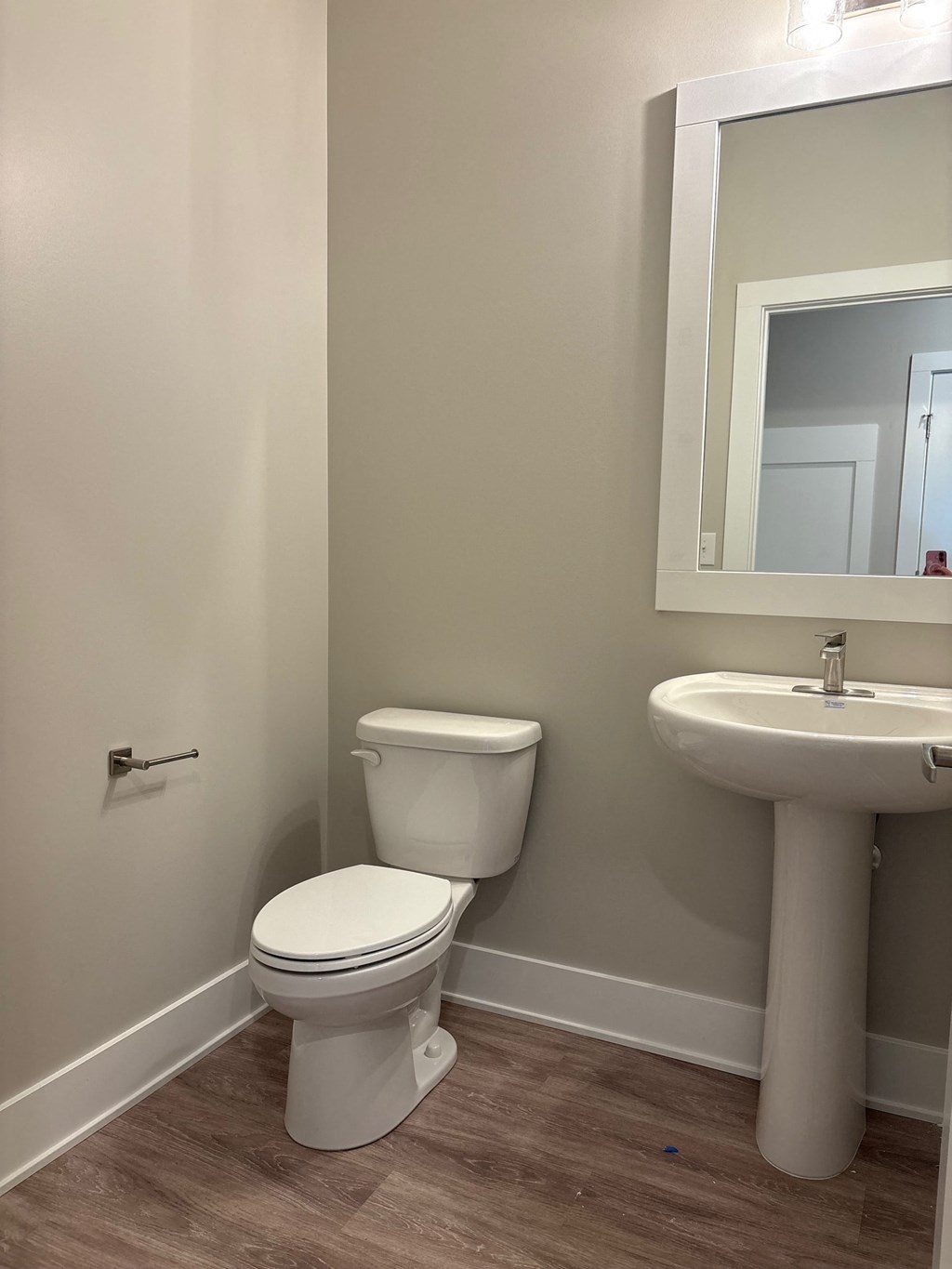 A white toilet and sink in a bathroom.