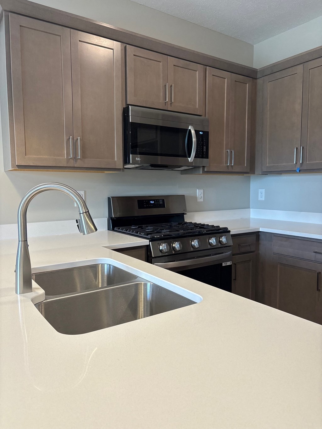 A kitchen with a stove, sink, and cabinets.
