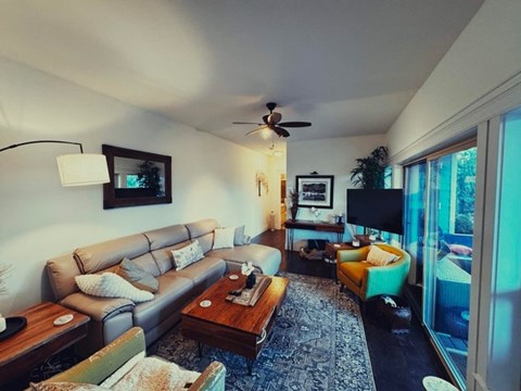 A living room with a grey couch and a wooden coffee table.