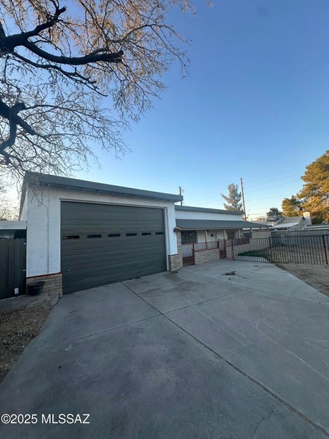 A white garage door is closed and the sky is blue.