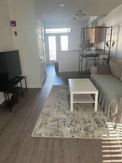 A living room with a white sofa and a rug.