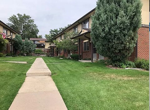 A grassy area in front of apartment buildings.