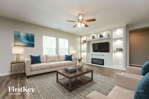 A living room with a couch, a coffee table, and a ceiling fan.