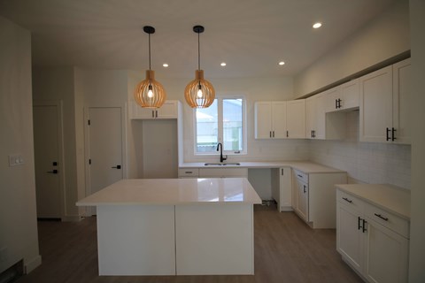 A kitchen with white cabinets and a large island.
