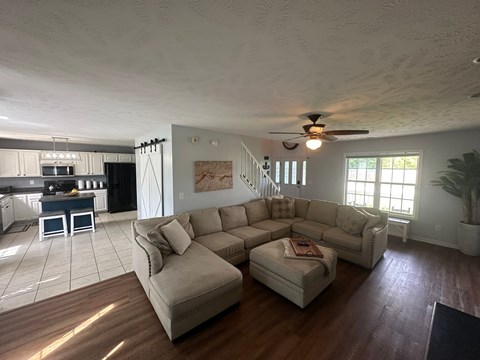 A living room with a couch and a ceiling fan.