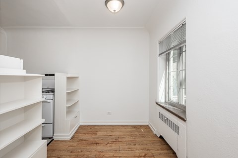 A white room with a window and a radiator.