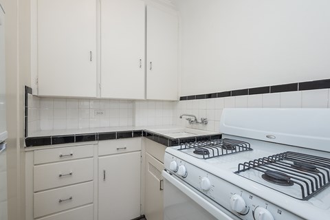 A white kitchen with a stove and cabinets.