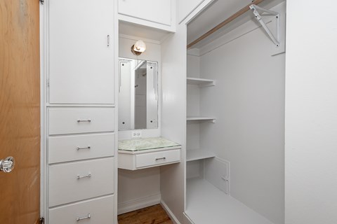 A white vanity with a mirror and a wooden door.