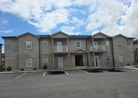 A row of houses with a parking lot in front.