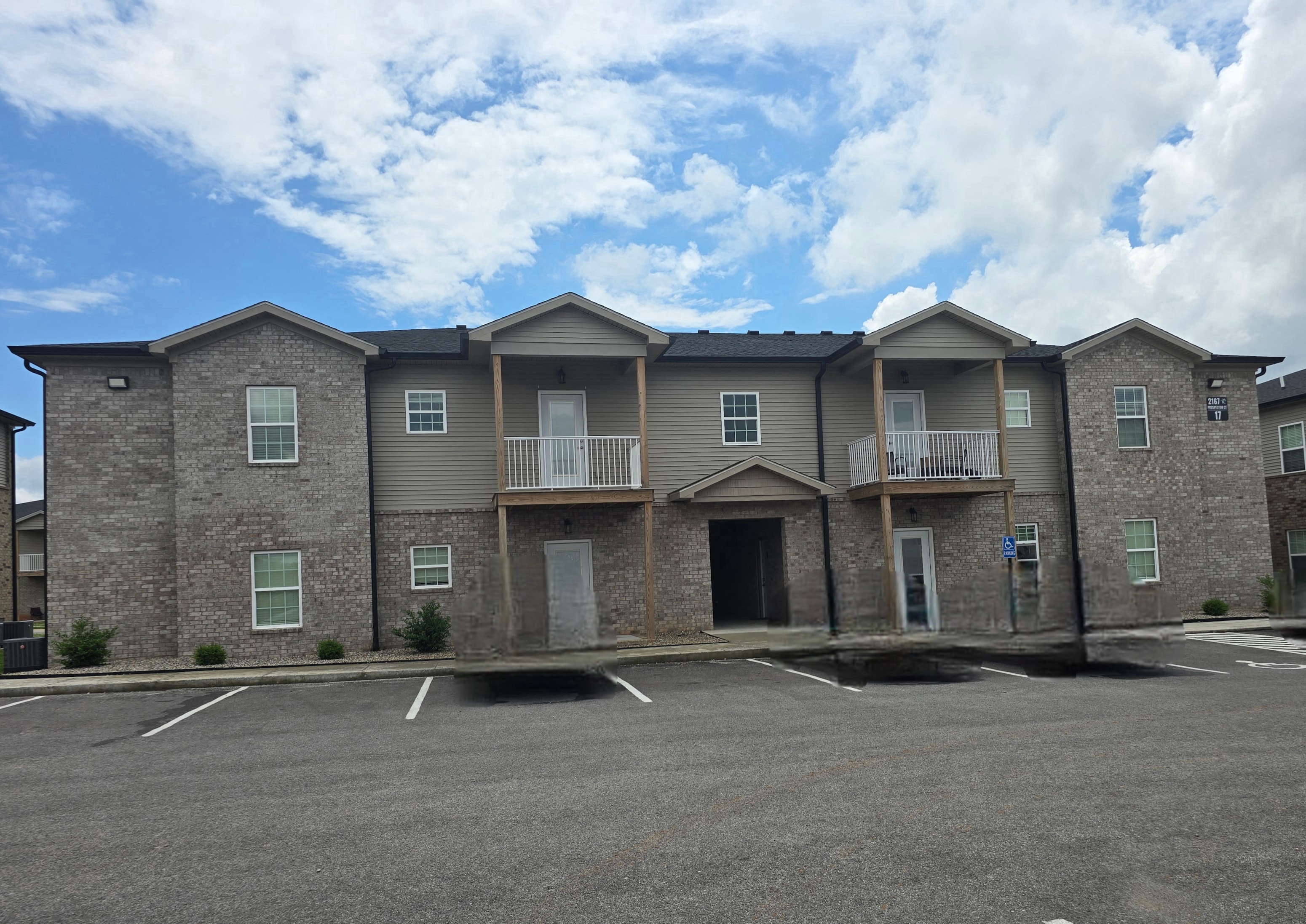 A row of houses with a parking lot in front.