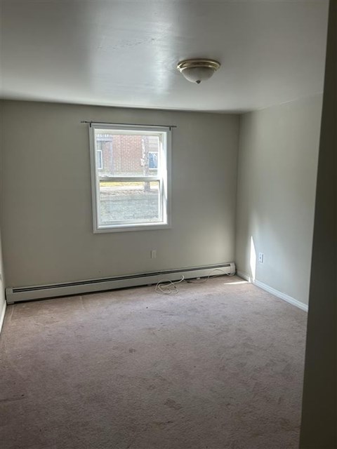 A room with a window and a ceiling light.