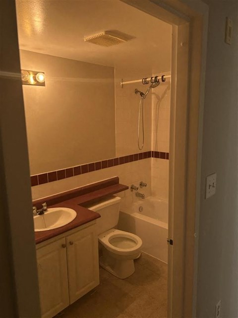 A bathroom with a toilet, sink, and bathtub.