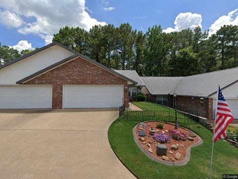 A house with a garage and a flag on the lawn.