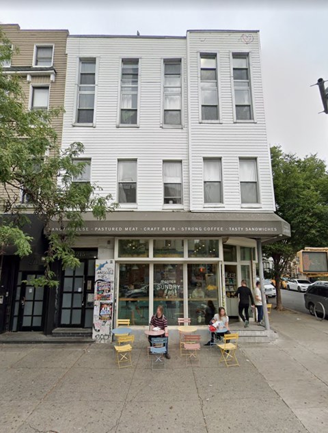 A white building with a sign that says "Sundry" on it.