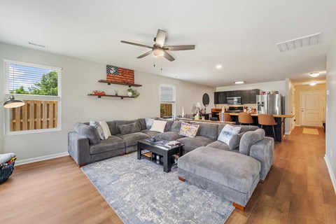 A living room with a grey couch and a wooden coffee table.