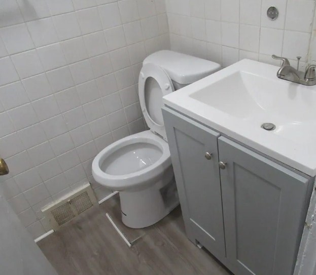 A white toilet sits next to a white sink in a bathroom.