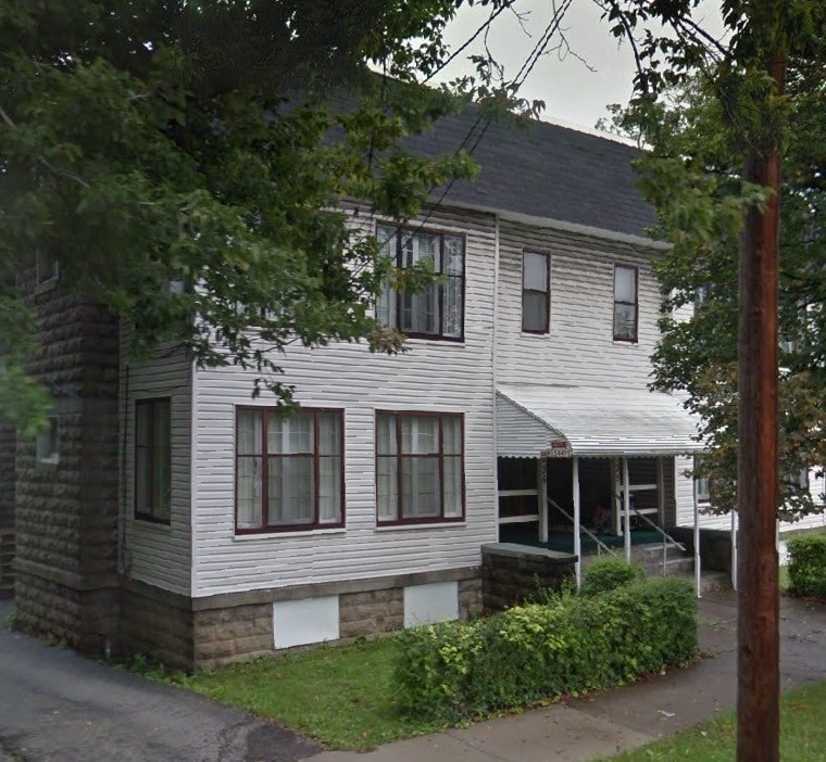 A two-story house with a porch and a covered entrance.