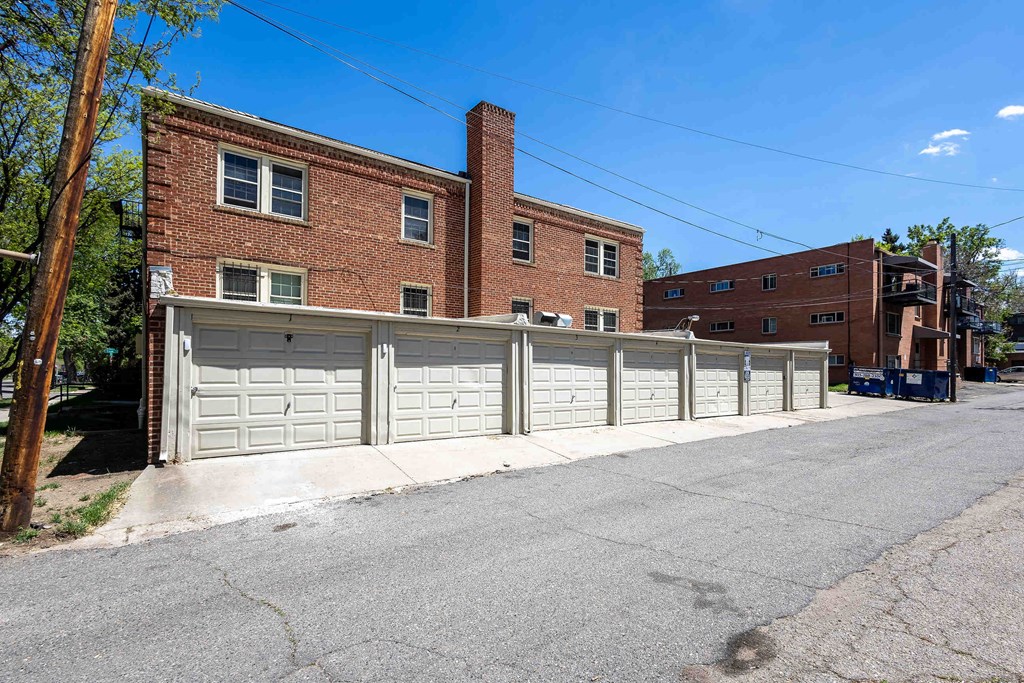 A row of garage doors in front of a brick building.