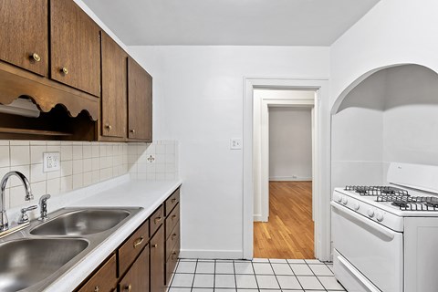 A kitchen with a white stove and a sink.
