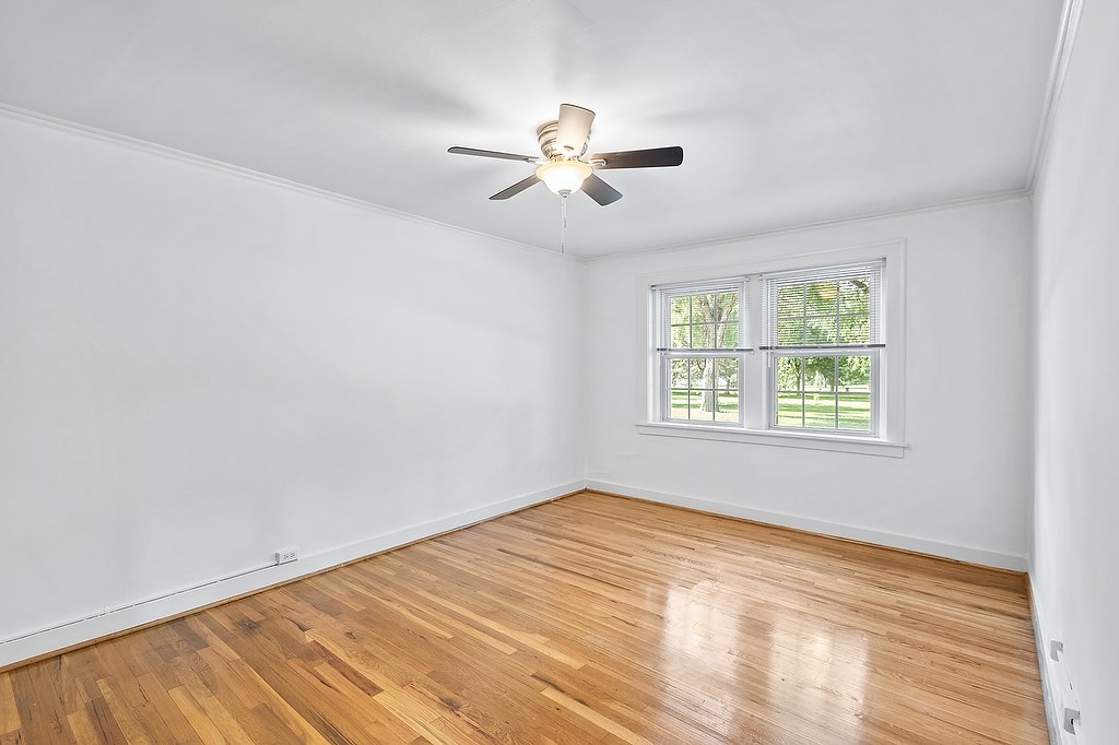 A room with a ceiling fan and a window.