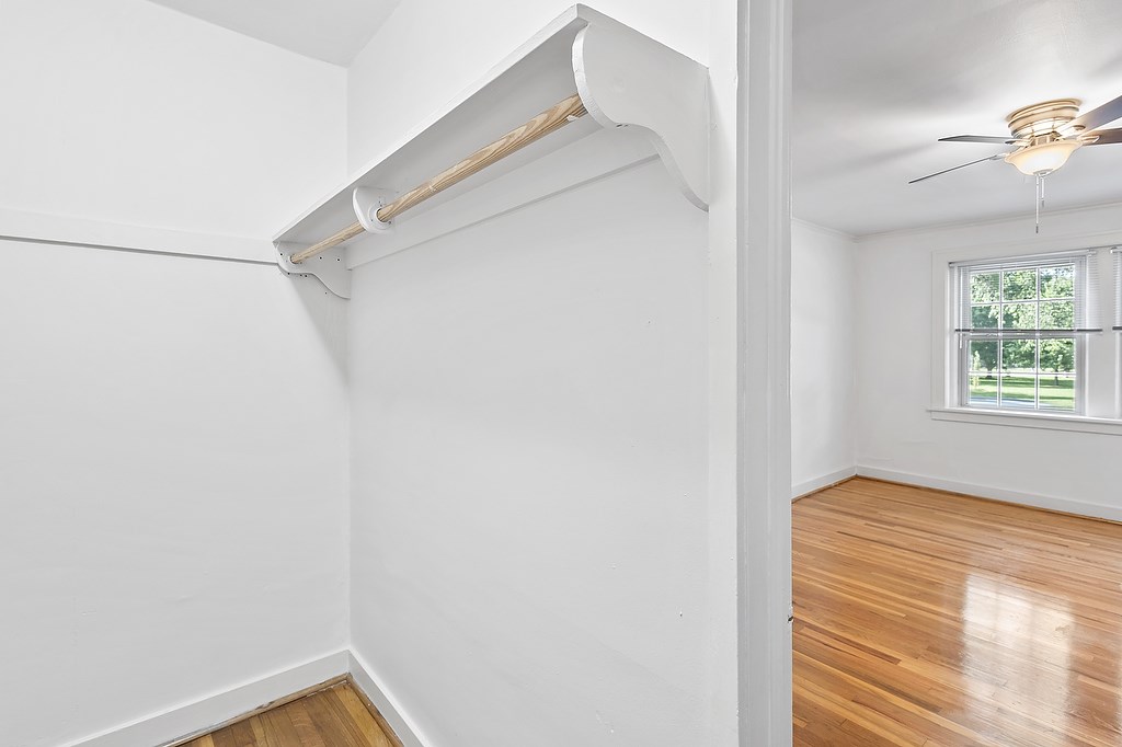 A room with a window and a ceiling fan.