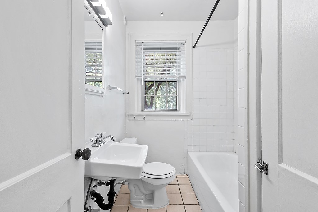 A white bathroom with a toilet, sink, and bathtub.