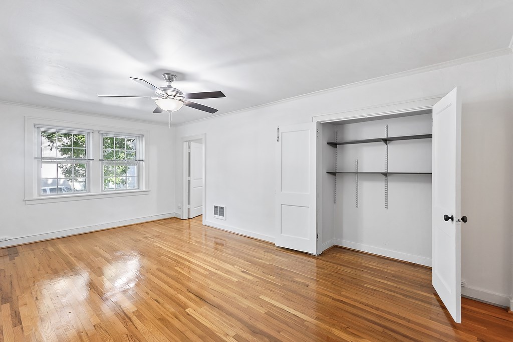 A room with a ceiling fan and a large open door.