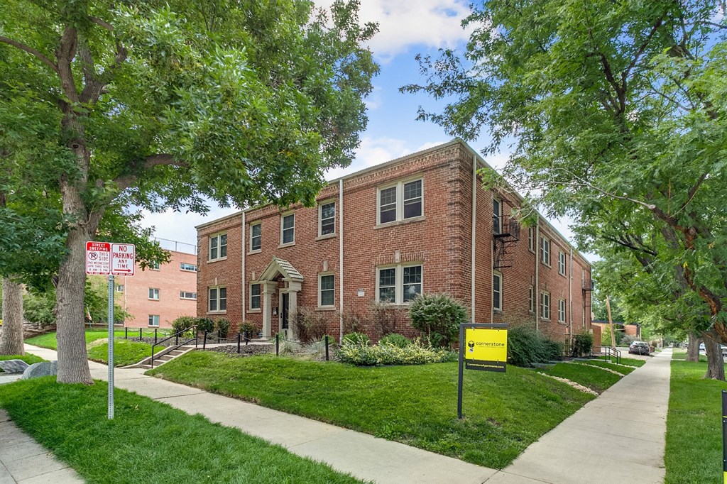 A red brick building with a sign in front of it.