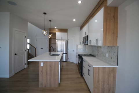A kitchen with a white counter top and wooden cabinets.