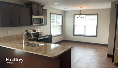 A kitchen with a sink, microwave, and oven.