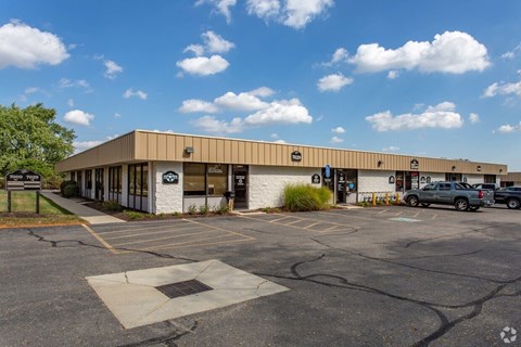 A parking lot in front of a building with a white facade and a sign that says "BMW".