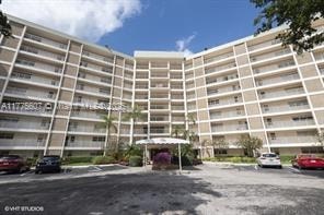 A large apartment complex with cars parked in front.