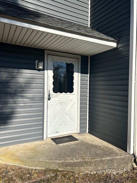 A white door with a diamond pattern on the side is closed.