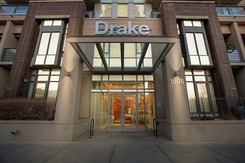 The entrance to a Drake building with a glass door and windows on either side.