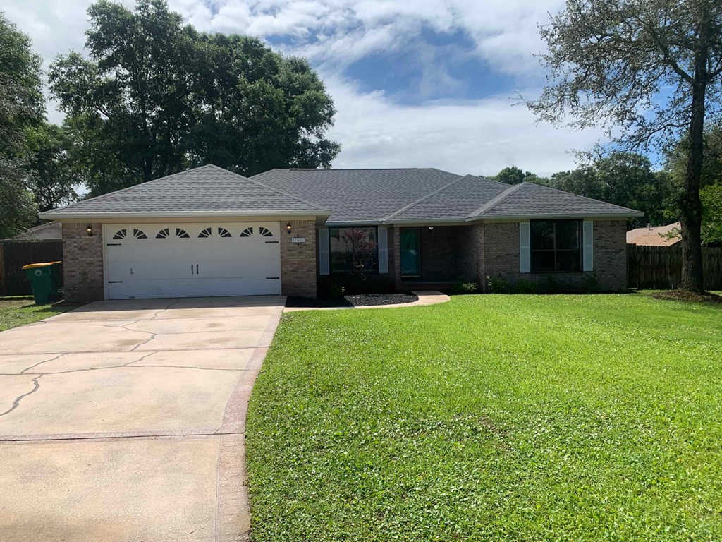 A house with a grey roof and a white garage door.