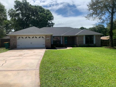 A house with a grey roof and a white garage door.