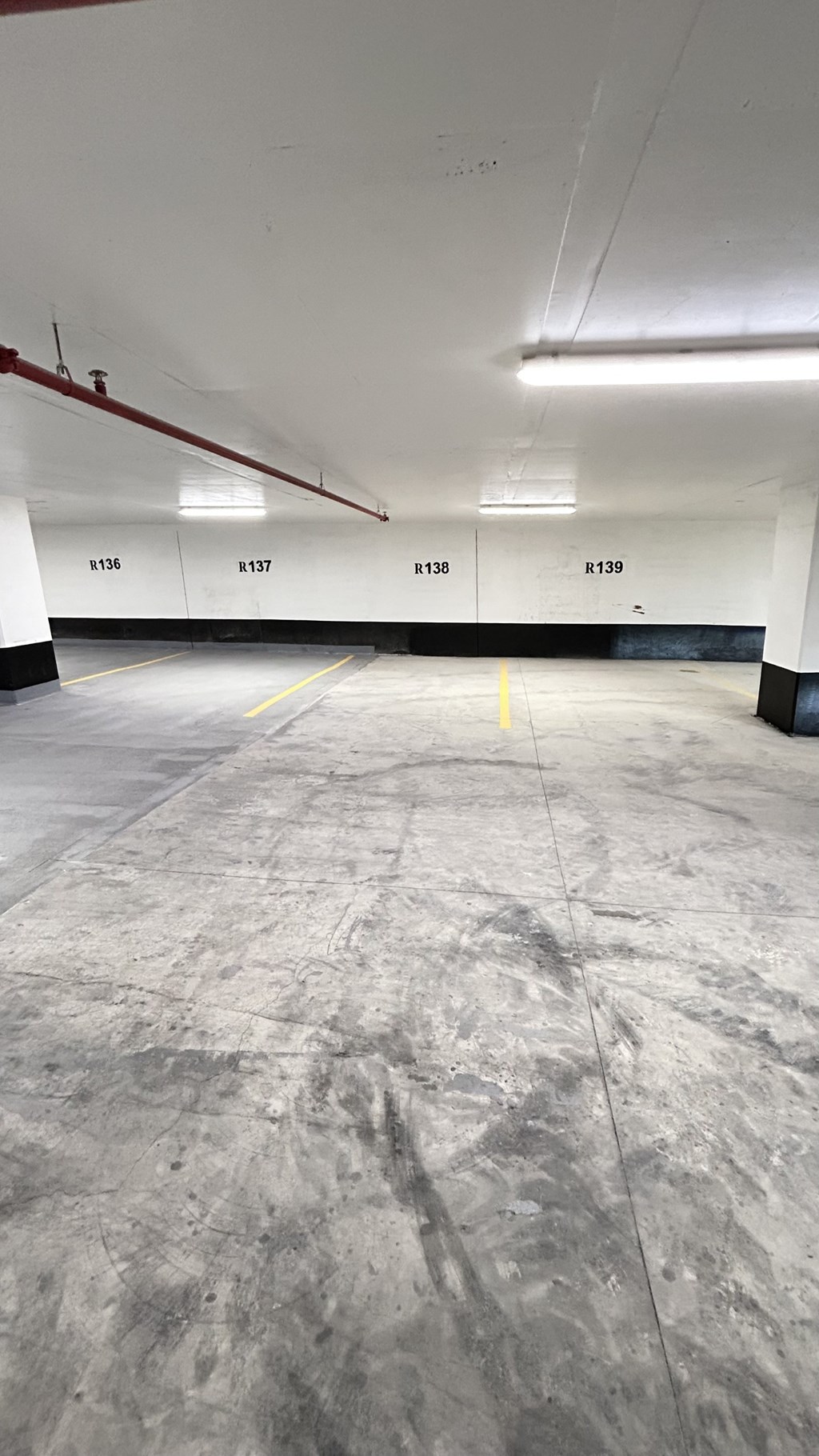 A large empty parking garage with yellow lines on the floor.