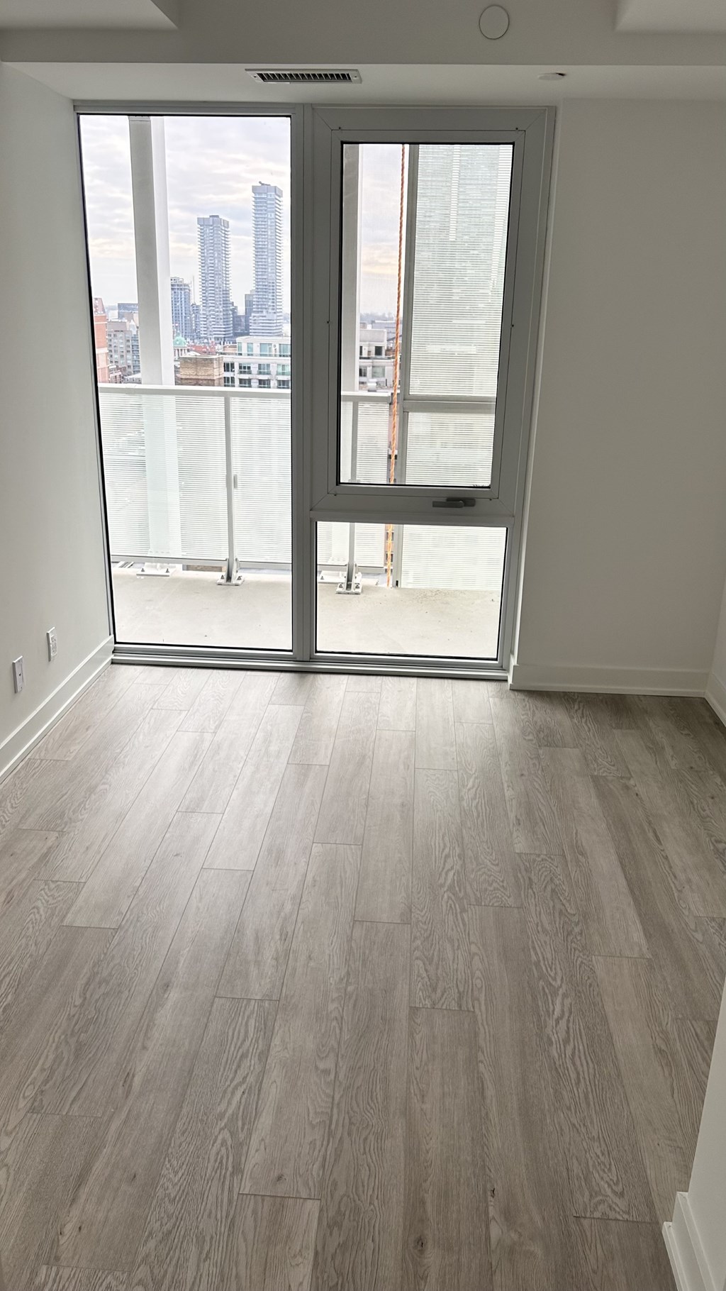 A room with a sliding glass door leading to a balcony.